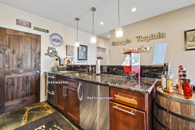kitchen featuring a sink, hanging light fixtures, dark stone countertops, and dishwasher