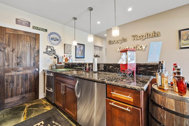 kitchen featuring dark stone counters, hanging light fixtures, a sink, and dishwasher