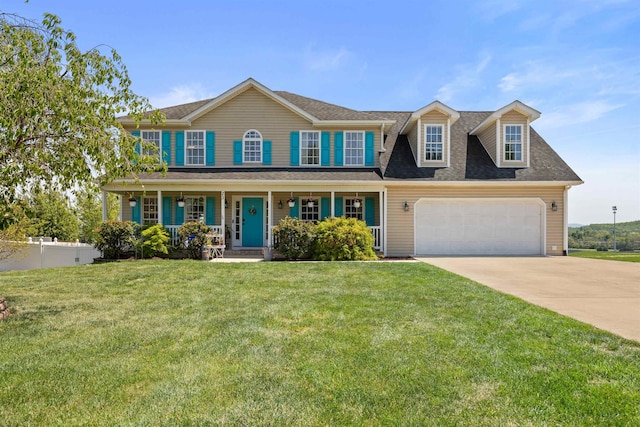 colonial home with fence, a front lawn, a garage, concrete driveway, and covered porch