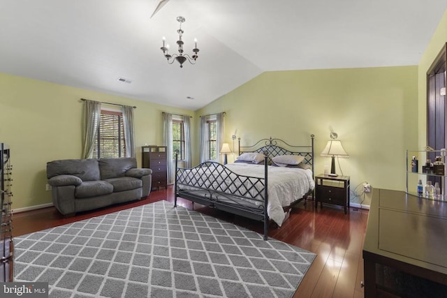 bedroom featuring baseboards, visible vents, dark wood finished floors, lofted ceiling, and a chandelier