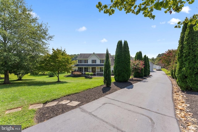 view of front of property with driveway and a lawn