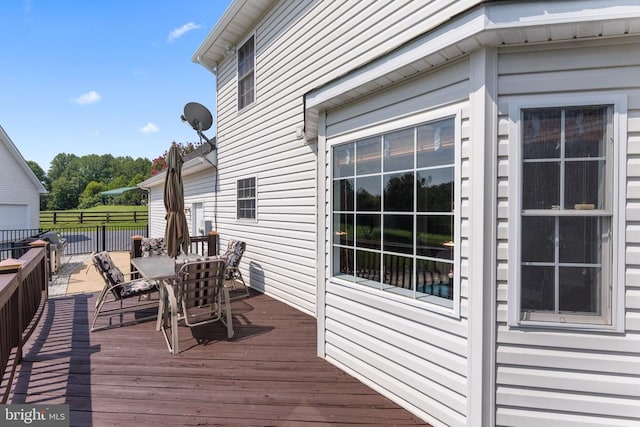 wooden terrace featuring outdoor dining area and fence