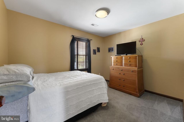 bedroom featuring visible vents, light carpet, and baseboards