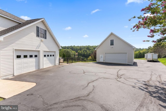 view of home's exterior featuring a garage, fence, and an outdoor structure