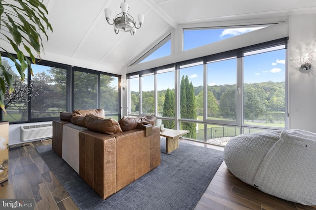 sunroom with lofted ceiling with beams, a forest view, a notable chandelier, and a wall mounted air conditioner