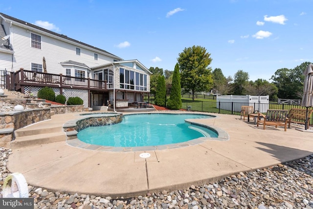 view of swimming pool featuring a fenced in pool, a sunroom, a patio area, fence, and an in ground hot tub