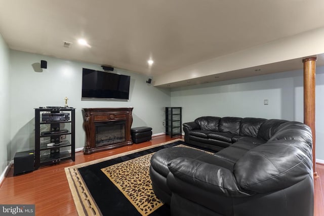 living room featuring recessed lighting, baseboards, wood finished floors, and a glass covered fireplace