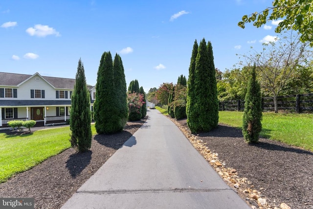 view of home's community with a yard and fence