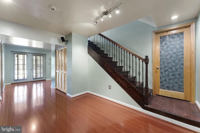 stairs featuring french doors, baseboards, and wood finished floors