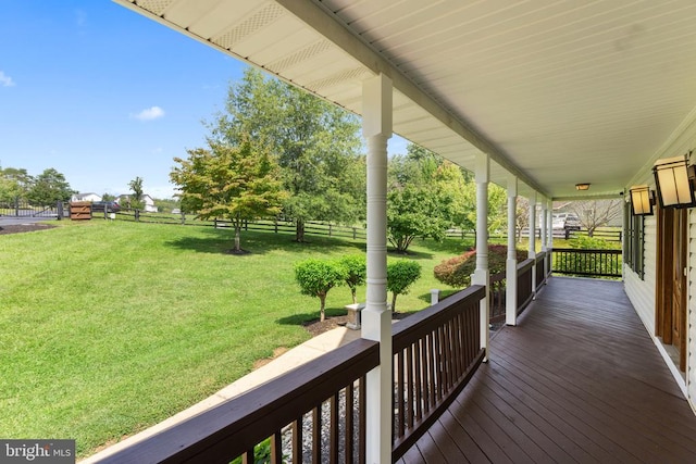 deck featuring covered porch and a yard