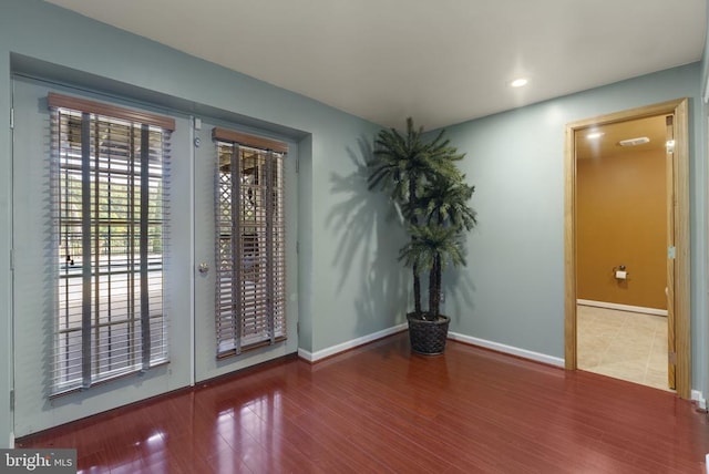 empty room with recessed lighting, baseboards, and wood finished floors