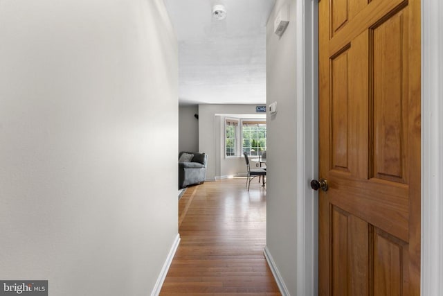 hallway with baseboards and wood finished floors