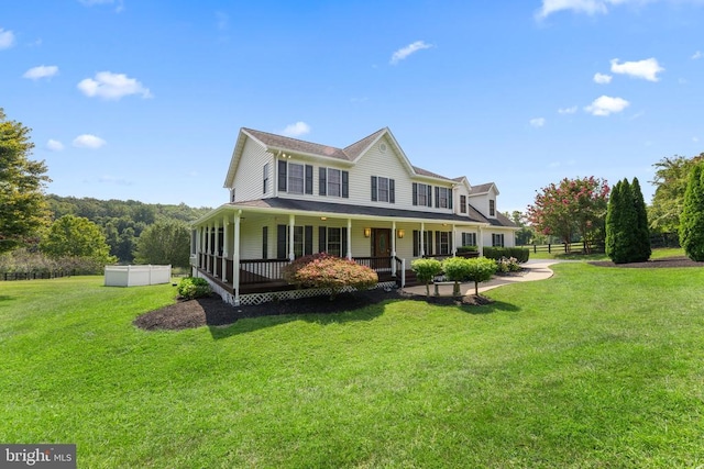 view of front facade with covered porch, fence, and a front yard