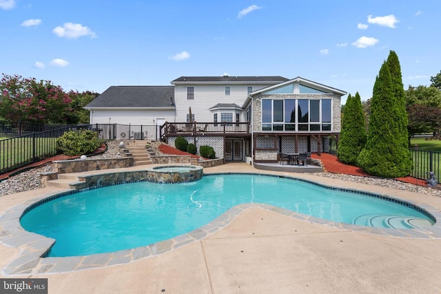 view of pool with a pool with connected hot tub, fence, a wooden deck, and a patio