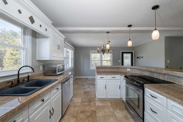 kitchen featuring stainless steel appliances, tile counters, white cabinets, and a sink