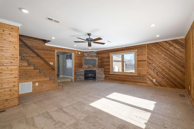 unfurnished living room with stairs, ornamental molding, carpet flooring, and visible vents