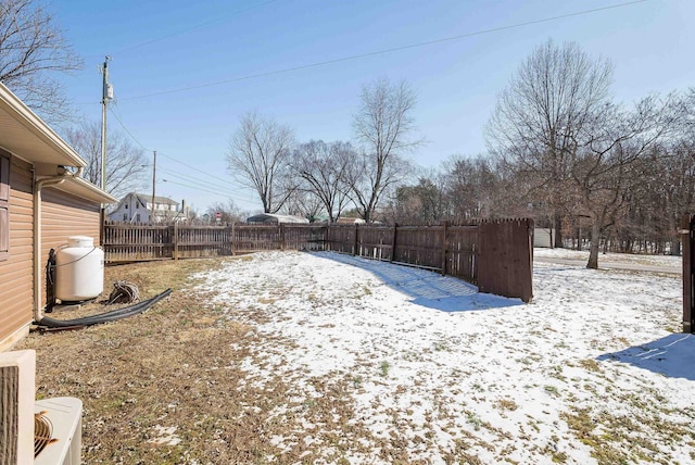 yard covered in snow featuring fence