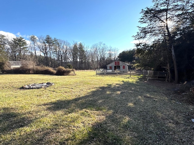 view of yard with a pole building, fence, and an outdoor structure