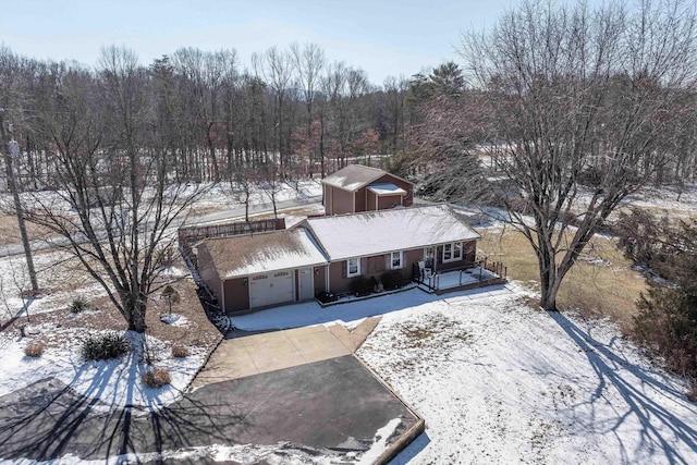 snowy aerial view featuring a forest view