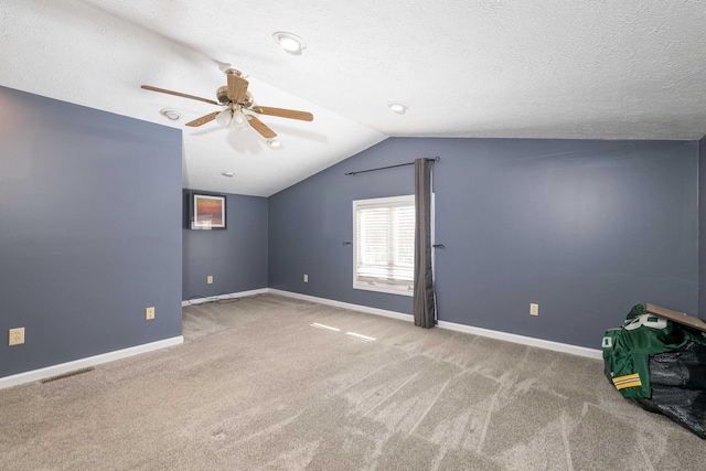 unfurnished room with vaulted ceiling, carpet flooring, visible vents, and baseboards