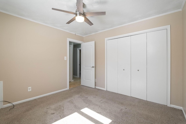 unfurnished bedroom with carpet, a closet, crown molding, and baseboards