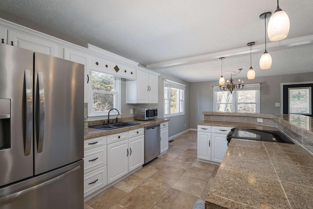 kitchen featuring tile countertops, appliances with stainless steel finishes, white cabinets, and a sink