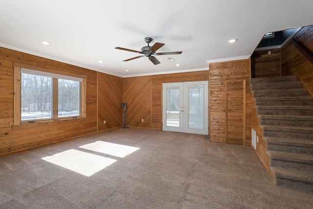 unfurnished room with carpet, stairway, ornamental molding, and french doors