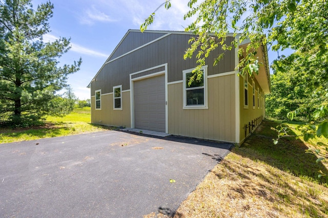 exterior space with a garage, driveway, and an outdoor structure