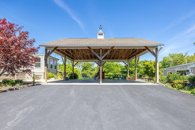 view of car parking with aphalt driveway and a carport