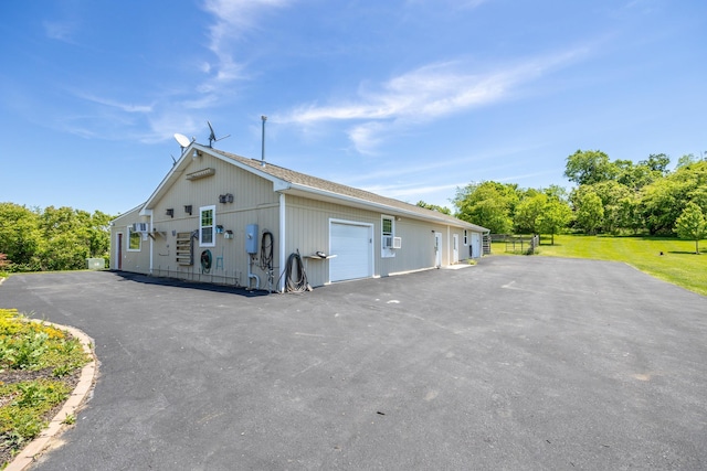 view of side of property featuring a detached garage and a lawn