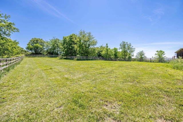 view of yard with a rural view and fence