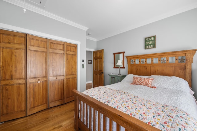 bedroom featuring a closet, light wood-type flooring, and crown molding