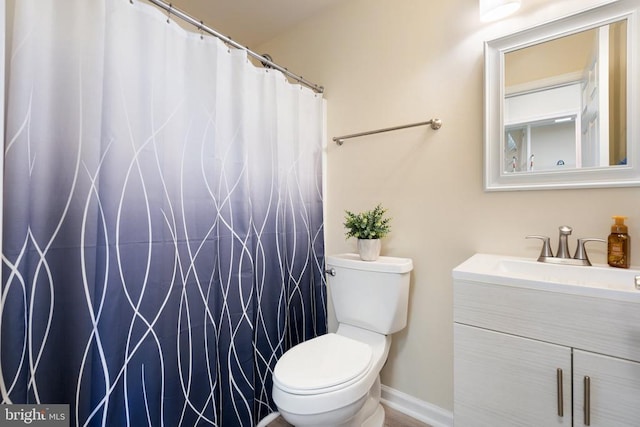 full bath with curtained shower, baseboards, toilet, and vanity