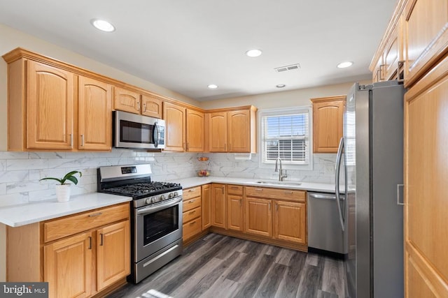 kitchen with visible vents, a sink, dark wood-style floors, appliances with stainless steel finishes, and light countertops