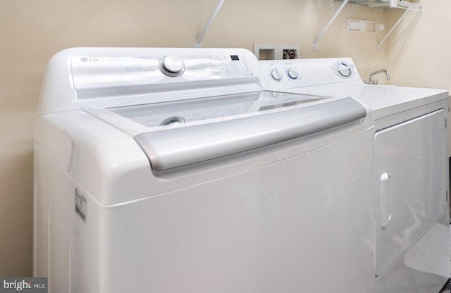 clothes washing area featuring washing machine and clothes dryer and laundry area