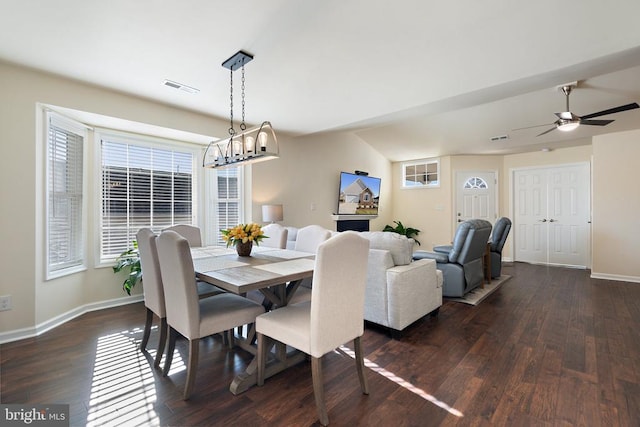 dining area featuring dark wood-style floors, visible vents, ceiling fan with notable chandelier, and baseboards