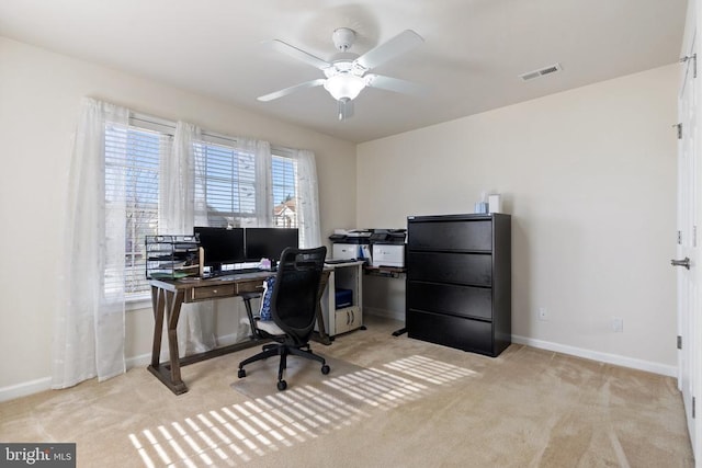 office area with baseboards, light colored carpet, visible vents, and ceiling fan