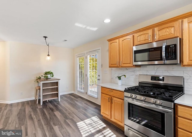 kitchen featuring stainless steel appliances, dark wood-style flooring, decorative backsplash, and light countertops