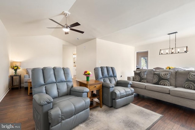 living room featuring vaulted ceiling, ceiling fan with notable chandelier, baseboards, and dark wood-style flooring