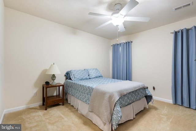 bedroom featuring visible vents, light carpet, baseboards, and a ceiling fan