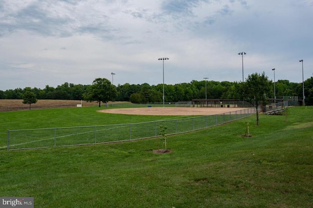 surrounding community with a yard, fence, and a rural view