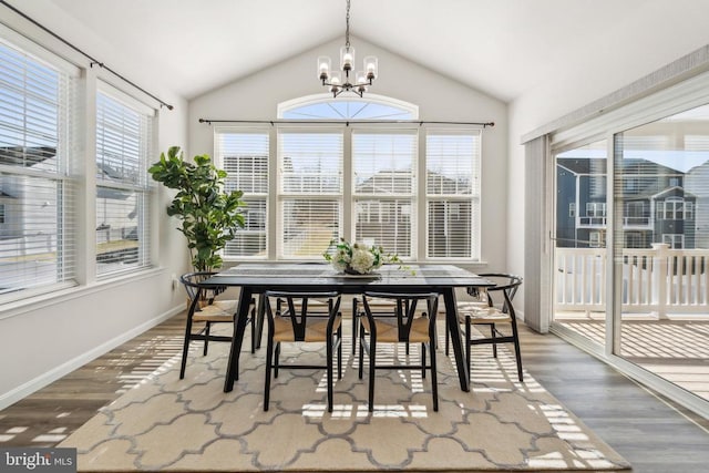 sunroom / solarium featuring an inviting chandelier, plenty of natural light, and vaulted ceiling