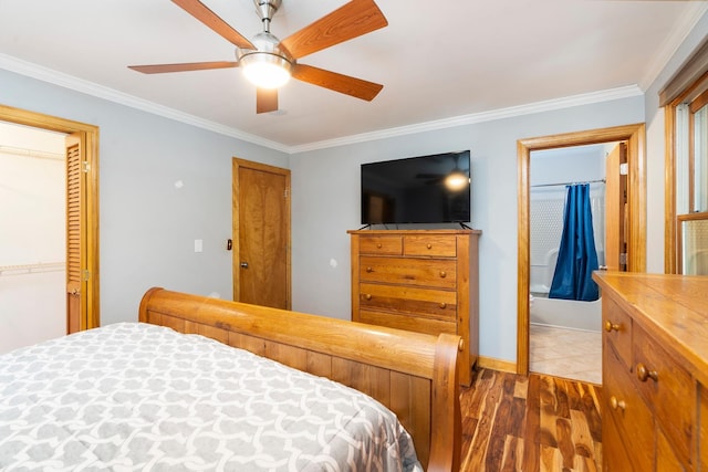 bedroom featuring multiple closets, wood-type flooring, ornamental molding, and ceiling fan