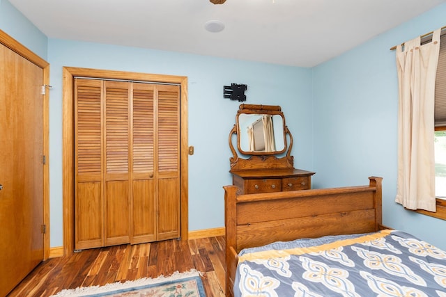 bedroom with ceiling fan, dark hardwood / wood-style flooring, and a closet