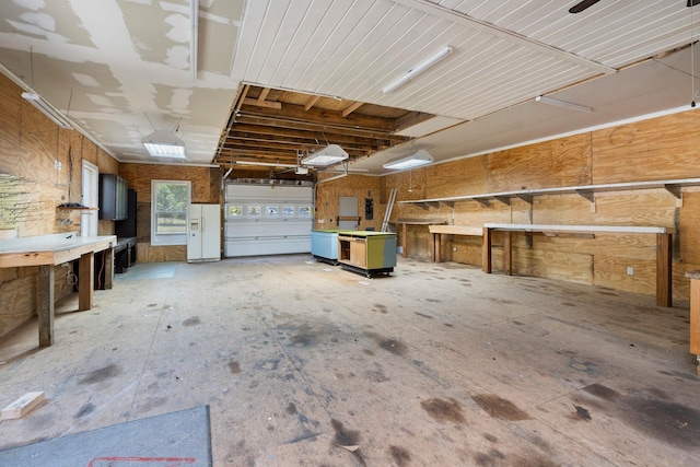 garage featuring a workshop area and white fridge with ice dispenser