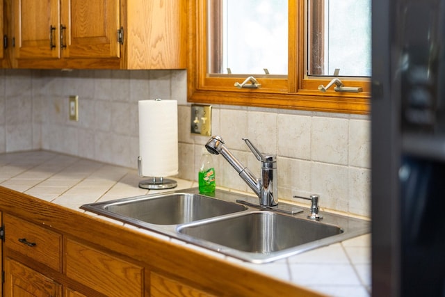 kitchen featuring tasteful backsplash, sink, and tile countertops