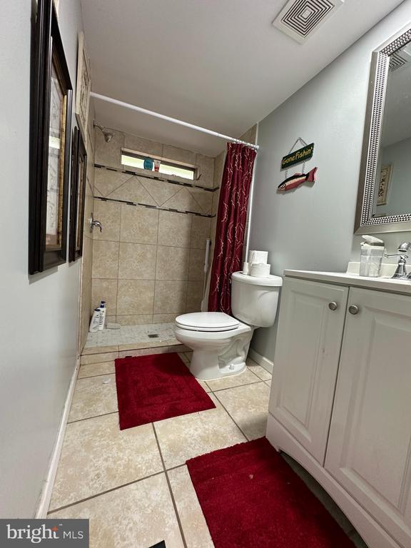 bathroom featuring vanity, toilet, tile patterned floors, and a shower with shower curtain