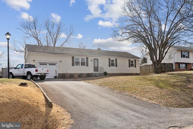 ranch-style house with a front yard, crawl space, fence, a garage, and driveway