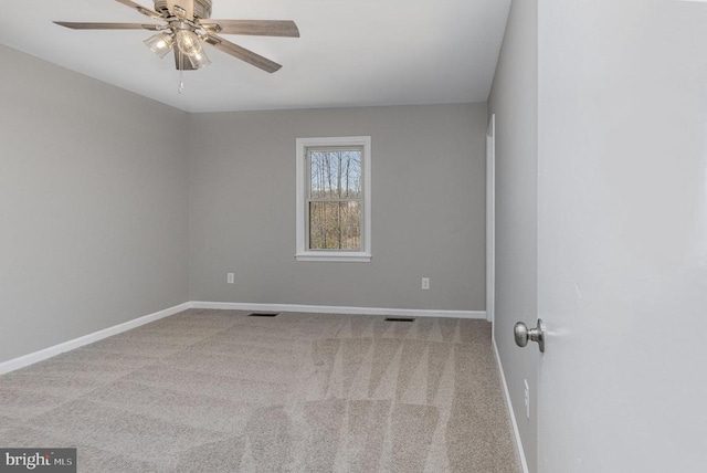 spare room featuring a ceiling fan, carpet, visible vents, and baseboards