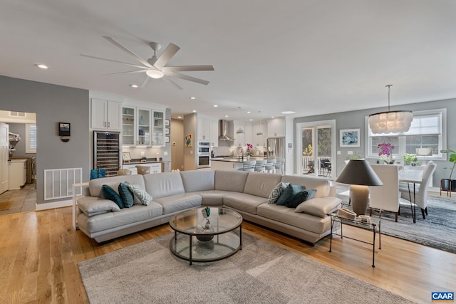 living room featuring a ceiling fan, recessed lighting, visible vents, and light wood finished floors